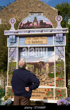 Regno Unito, Inghilterra, Derbyshire, Eyam, poco Edge, visitatore guardando alla testa della città ben medicazione Foto Stock