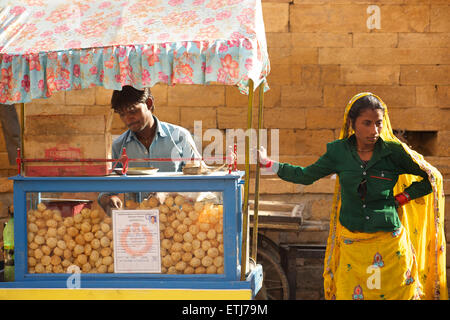 Indian street vendor e donna in sari. Jaisalmer, Rajasthan, India Foto Stock