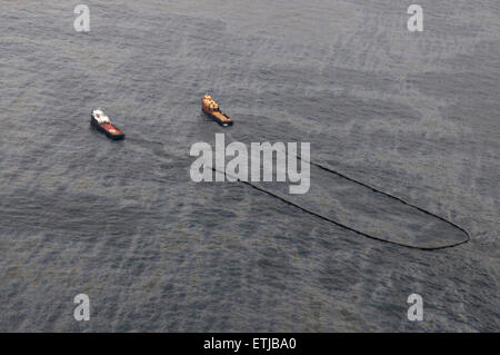 Pulire equipaggi di condotta utilizzare resistente al fuoco il braccio per raccogliere il petrolio greggio per una combustione controllata seguendo la BP Deepwater Horizon oil spill disastro come gli sforzi per contenere e pulire i milioni di galloni di equipaggio continuare Maggio 8, 2010 nel Golfo del Messico. Foto Stock