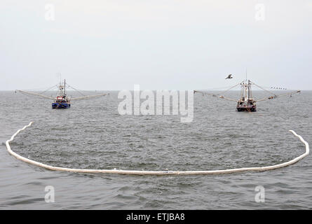 Gamberetti trainare resistente al fuoco di olio-braccio di contenimento come i loro equipaggi di condotta in situ di bruciare la formazione al largo a seguito della BP Deepwater Horizon oil spill disastro come gli sforzi per contenere e pulire i milioni di galloni di equipaggio continuare Maggio 3, 2010 vicino a Venezia, Louisiana. Foto Stock