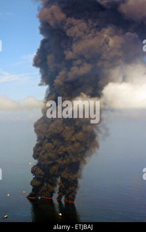 Nuvole scure riempiono il cielo come clean up equipaggi di condotta ustioni controllata di olio raccolte dalla superficie del Golfo del Messico a seguito della BP Deepwater Horizon oil spill disastro come gli sforzi per contenere e pulire i milioni di galloni di equipaggio continuare il 19 maggio 2010 nel Golfo del Messico. Foto Stock