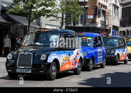 Taxi neri in attesa in una stazione di sosta dei taxi di Russell Street, Covent Garden di Londra, Inghilterra, Regno Unito Foto Stock