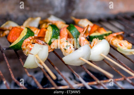 Gli spiedini di gamberi su un barbecue Foto Stock