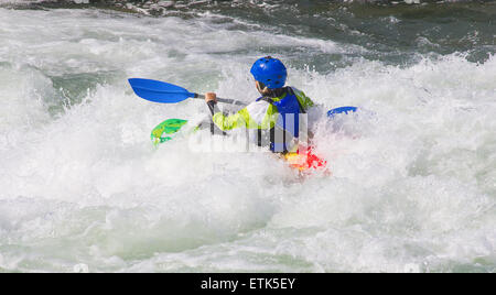 Kayaker femmina nelle acque bianche del fiume tghe Foto Stock