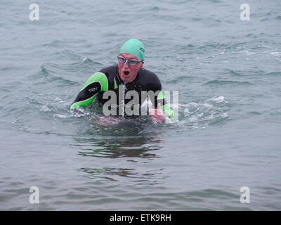 Portsmouth, Regno Unito. 14 Giugno, 2015. Un concorrente emerge dal mare durante il Portsmouth provare un tri triathlon evento. La manifestazione consisteva in un certo numero di sprint triathlon di diverse lunghezze per ospitare diverse abilità. Credito: simon evans/Alamy Live News Foto Stock