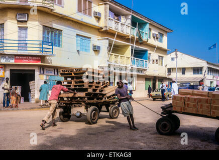 Gli uomini del Gambia con consegna di carrelli, strada dello shopping, Banjul (Gambia, Africa occidentale Foto Stock