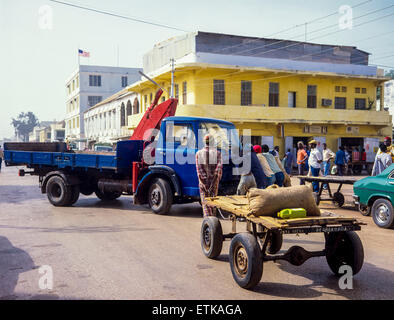 Uomo gambiana con consegna del carrello e spingere le persone autocarro, Banjul (Gambia, Africa occidentale Foto Stock