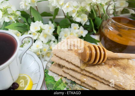 Una sana colazione con biscotti integrali miele e tè chokeberry Foto Stock