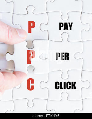 La mano di un uomo di affari di completare il puzzle con l'ultimo pezzo mancante.Concetto di immagine di Business acronimo PPC come Pay Per Click Foto Stock