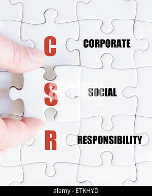 La mano di un uomo di affari di completare il puzzle con l'ultimo pezzo mancante.Concetto di immagine di Business acronimo CSR come la responsabilità sociale delle imprese Foto Stock