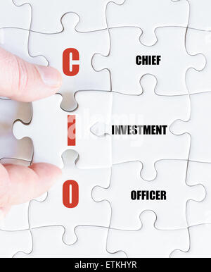 La mano di un uomo di affari di completare il puzzle con l'ultimo pezzo mancante.Concetto di immagine di Business acronimo CIO come Chief Investment Officer Foto Stock