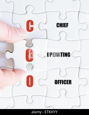 La mano di un uomo di affari di completare il puzzle con l'ultimo pezzo mancante.Concetto di immagine di Business acronimo COO come Chief Operating Officer Foto Stock