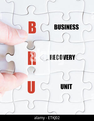 La mano di un uomo di affari di completare il puzzle con l'ultimo pezzo mancante.Concetto di immagine di Business acronimo BRU come Business Unit di recupero Foto Stock