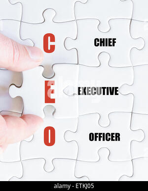 La mano di un uomo di affari di completare il puzzle con l'ultimo pezzo mancante.Concetto di immagine di Business acronimo CEO come Chief Executive Officer Foto Stock