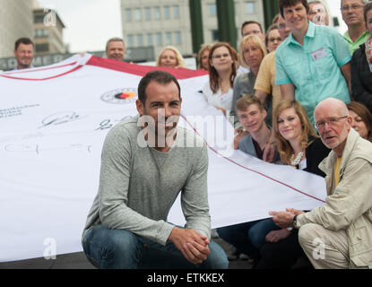 Berlino, Germania. 14 Giugno, 2015. Ex nazionale tedesco di calcio team player Christoph Metzelder (C) pone con i donatori di sangue nella parte anteriore di un sovradimensionato jersey della Croce Rossa tedesca durante una unità di sangue dell'organizzazione segnando il mondo di donatori di sangue giornata a Berlino, Germania, 14 giugno 2015. Foto: PAOLO ZINKEN/dpa/Alamy Live News Foto Stock