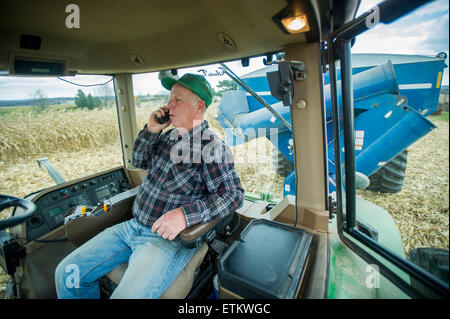 Agricoltore parlando sul suo telefono cellulare nella sua cabina del trattore in Jarrettsville, Maryland, Stati Uniti d'America Foto Stock