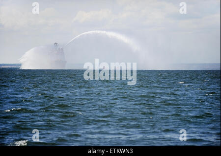 Un fireboat spruzza acqua in aria durante un trapano di mare Foto Stock