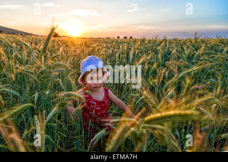 Ritratto di una bambina di giocare in un campo di grano Foto Stock