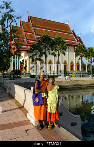 I monaci, i novizi di fronte alla facciata a sud di Wat Klang tempio, Buri Ram, Buriram Provincia, Isan, Isaan, Thailandia Foto Stock