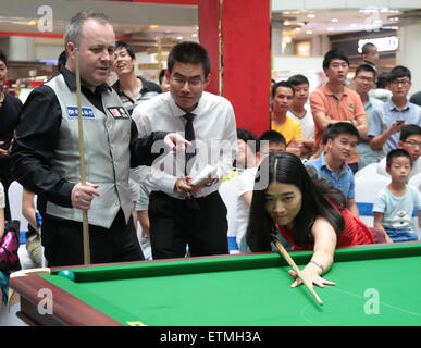 Wuhan, Cina. 14 Giugno, 2015. Scottish professional snooker player John Higgins insegna una ragazza quando frequenta una attività a Wuhan, provincia di Hubei in Cina il 14 maggio 2015. Credito: Panda occhio/Alamy Live News Foto Stock