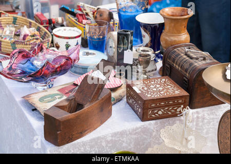 Visualizzazione tipica di articoli per la casa in vendita stabiliti sul tavolo al bagagliaio della vettura fair nick knacks bicchieri jewelery di vetro piano in legno Foto Stock