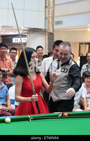 Wuhan, Cina. 14 Giugno, 2015. Scottish professional snooker player John Higgins insegna una ragazza quando frequenta una attività a Wuhan, provincia di Hubei in Cina il 14 maggio 2015. Credito: Panda occhio/Alamy Live News Foto Stock