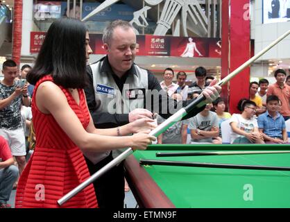 Wuhan, Cina. 14 Giugno, 2015. Scottish professional snooker player John Higgins insegna una ragazza quando frequenta una attività a Wuhan, provincia di Hubei in Cina il 14 maggio 2015. Credito: Panda occhio/Alamy Live News Foto Stock