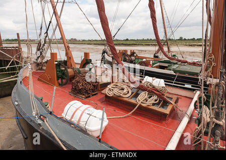 Moored vecchi barconi a vela a Hythe Quay a lowtide supportato da limo e fango e letti di sabbia di fiume Chelmer Foto Stock