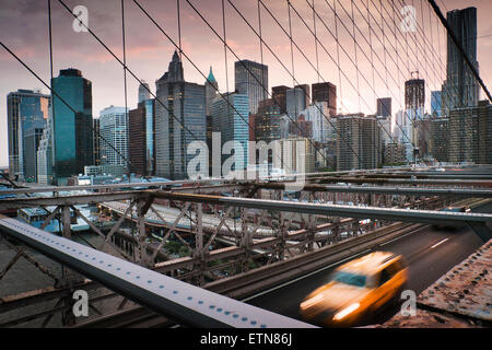 Yellow Cab di attraversare il Ponte di Brooklyn al tramonto, New York, Stati Uniti d'America Foto Stock