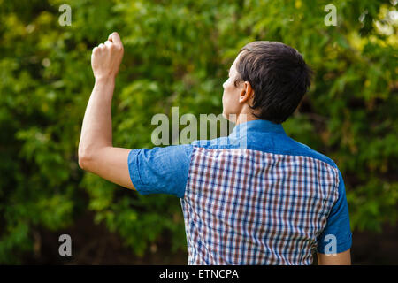 Indietro man mano che scrive in aria su uno sfondo verde street tr Foto Stock