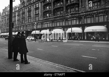 La polizia di due di tenere un occhio sui Harrods come ultimo minuto agli acquirenti di ottenere i regali di Natale in, Londra. Il 23 dicembre 1978. Foto Stock