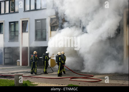 I vigili del fuoco sono impegnati a spegnere un incendio in una casa Foto Stock