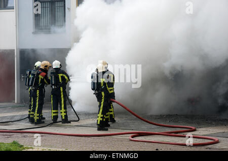 I vigili del fuoco sono impegnati a spegnere un incendio in una casa Foto Stock