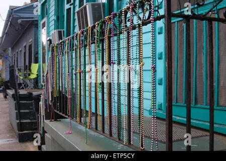 Mardi Gras beads appesi sulle ringhiere di metallo sul portico del legno di un clapboard House di New Orleans Foto Stock