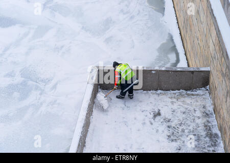 Pulizia del ponte. Unidentified irriconoscibile lavoratore rimuove la neve dalle strutture del Patriarca ponte pedonale su Foto Stock