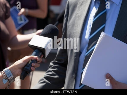 Giornalista rende media intervista con irriconoscibile politico o imprenditore Foto Stock