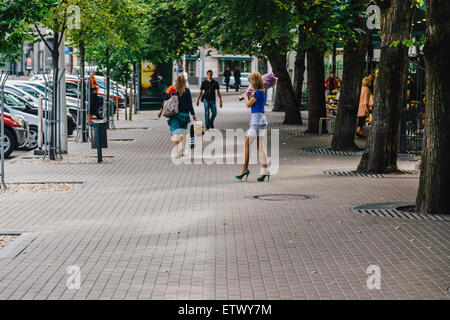 Giovane donna bionda che trasportano mazzo di fiori comprato al mercato dei fiori, Terbatas Iela (street), Riga, Lettonia Foto Stock