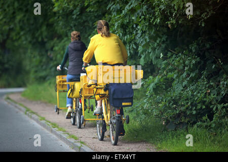 Andare ad Amburgo in Germania, portalettere di Deutsche Post AG su le loro biciclette Foto Stock