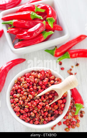 Il peperoncino in un recipiente e su un tavolo Foto Stock