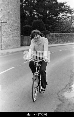 Pam Ayres cavalcare la sua bicicletta vicino alla sua casa in un villaggio in Oxfordshire. Il 12 maggio 1977. Foto Stock