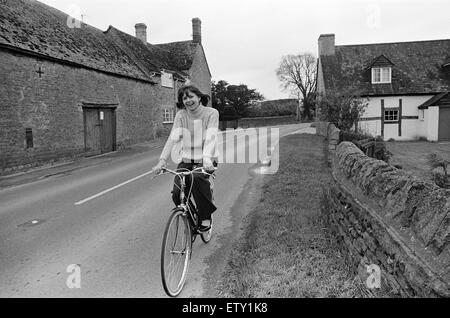 Pam Ayres cavalcare la sua bicicletta vicino alla sua casa in un villaggio in Oxfordshire. Il 12 maggio 1977. Foto Stock