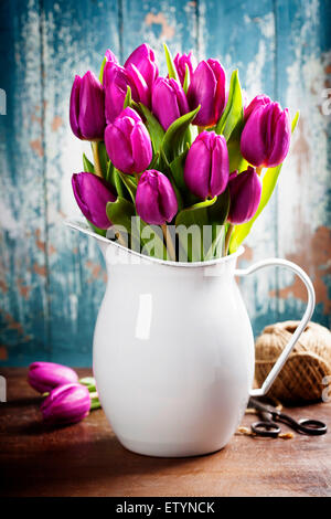 Viola i tulipani, attrezzi da giardino e uova di pasqua su una superficie di legno. Studio fotografico Foto Stock