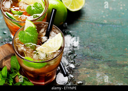 Ingredienti per rendere mojito (cubetti di ghiaccio, foglie di menta, zucchero e calce rustico sfondo) Foto Stock