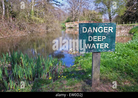 Pericolo in acqua profonda segno accanto al laghetto Foto Stock