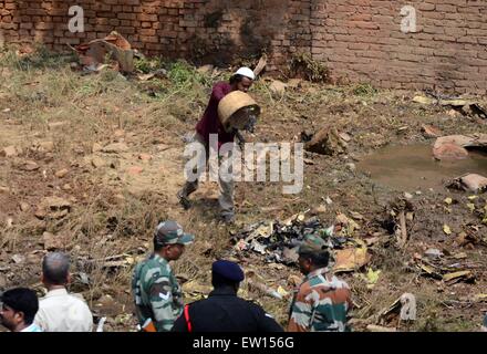 Di Allahabad, India. 16 Giugno, 2015. Persone raccogliere detriti della Jaguar degli aerei da caccia della forza aerea indiana si è schiantato questa mattina a Chaka in Naini nei pressi di Allahabad in Uttar Pradesh. Entrambi i piloti sono riusciti a espellere in modo sicuro. Il piano che aveva preso il largo a 7:25 am dall'aria Bamrauli strip di Allahabad era su una formazione di routine sortie. I piloti secondo come riferito ha inviato segnali per il personale di terra che vi è stata una delle principali tecniche di glitch con il velivolo. © Prabhat Kumar Verma/Pacific Press/Alamy Live News Foto Stock