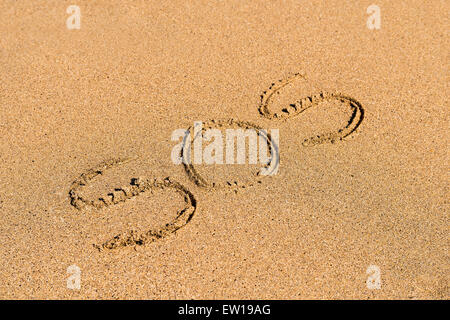 Aiutare a firmare tracciata sulla spiaggia di sabbia Foto Stock