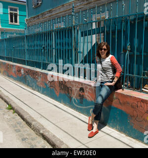 Ritratto di una donna appoggiata contro una recinzione, Valparaiso, Cile Foto Stock