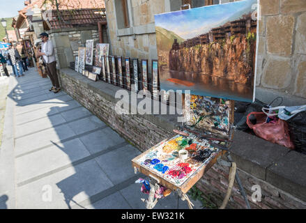 L'uomo vendere i suoi dipinti su una strada di UNESCO Città storica di Mtskheta, Georgia Foto Stock