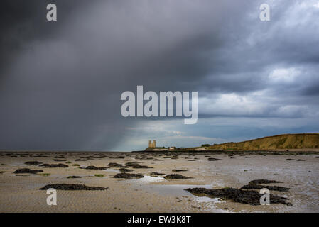 Vista della pioggia lambente spiaggia sabbiosa a bassa marea, con il XII secolo la chiesa in rovina in distanza, la chiesa di Santa Maria, Reculver, Foto Stock