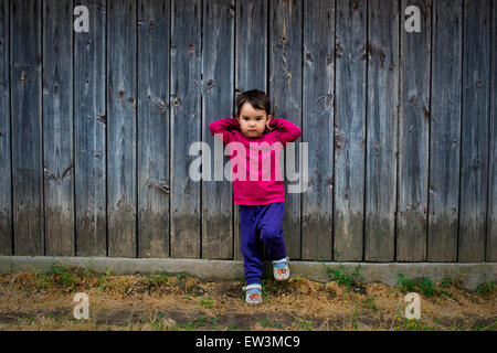 Estate ritratto di un simpatico bambina di due anni entro la recinzione Foto Stock